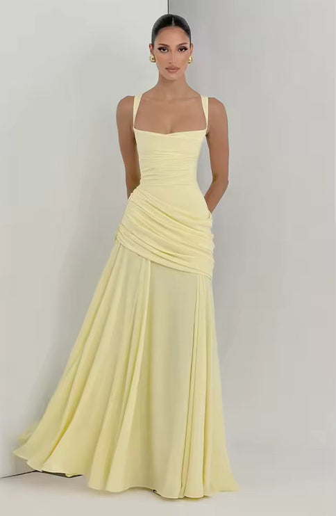Full-length pale yellow formal maxi dress with asymmetrical wrap and flowing skirt