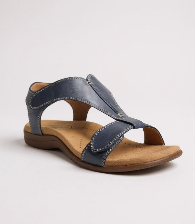 Navy blue leather t-strap sandal with contrast stitching and padded footbed