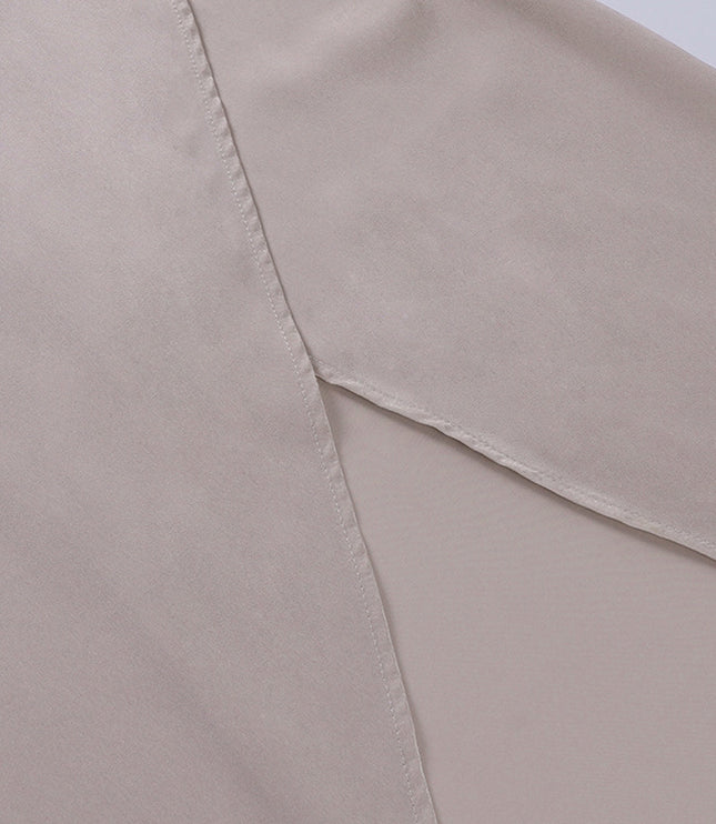 Close-up of the high side slit on the champagne V-neck maxi slip dress, the inner lining and careful tailoring.