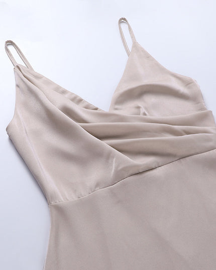 Top-down view of the draped V-neckline and delicate spaghetti straps of a beige women's maxi slip dress.