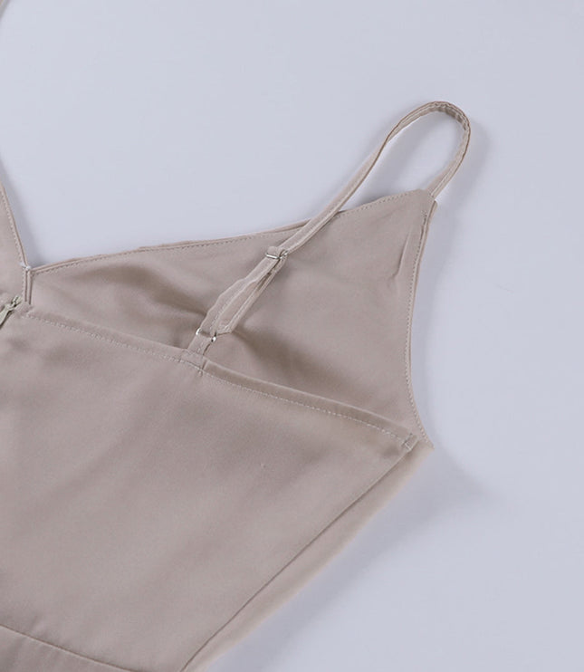 Close-up back detail of a champagne V-neck maxi slip dress, showing the adjustable spaghetti straps and zipper closure.