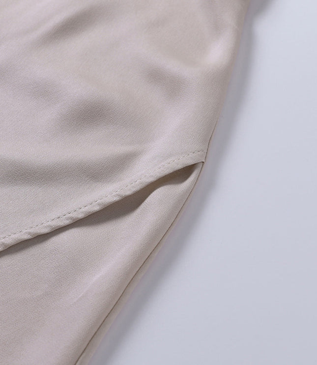 Detail of the side seam and fabric overlap on the champagne maxi slip dress, showing the construction of the slit.
