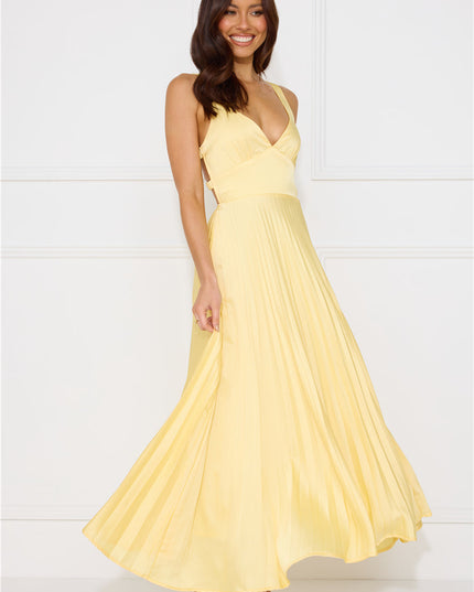 Side profile of yellow maxi dress showing v-neckline and flowing pleated skirt