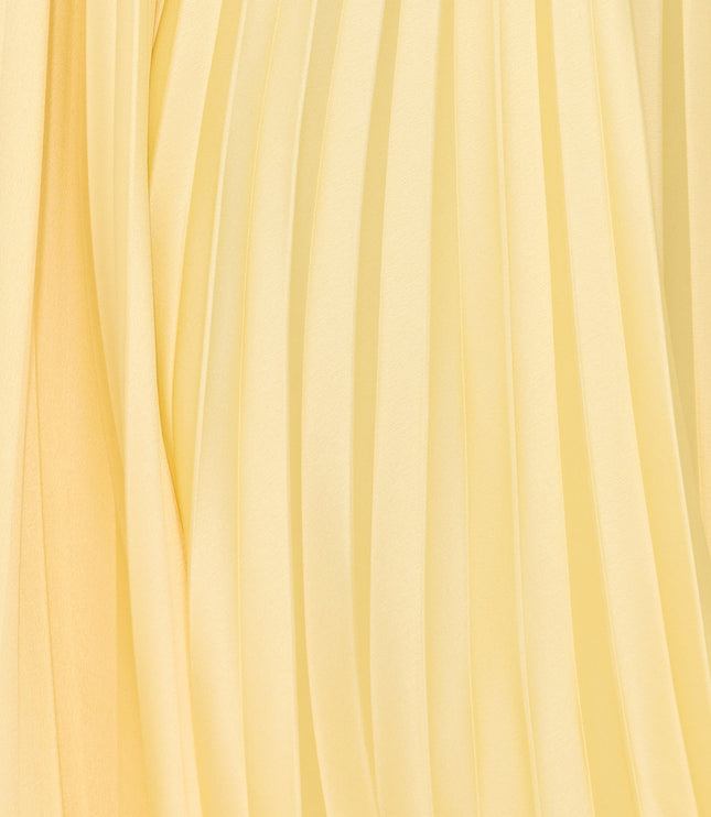 Close-up of pale yellow pleated fabric texture on maxi dress skirt