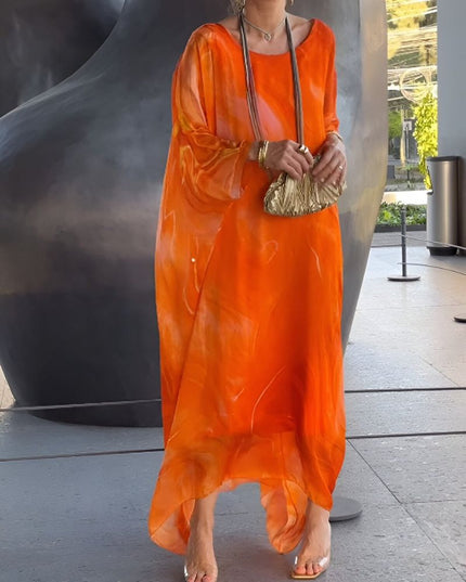 Bright orange abstract print maxi dress with sheer sleeves and breezy resort style