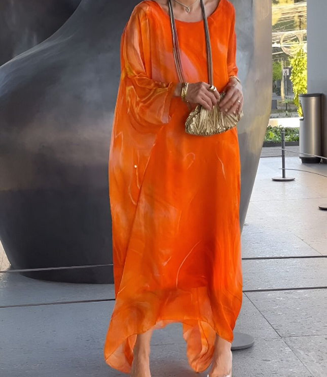 Bright orange abstract print maxi dress with sheer sleeves and breezy resort style