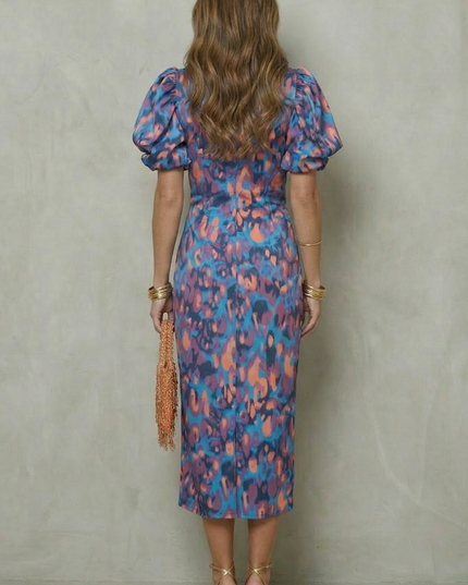 Back view of abstract print midi dress with puff sleeves and fitted silhouette