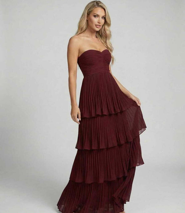 Burgundy strapless wedding guest dress with fitted bodice and tiered maxi hem