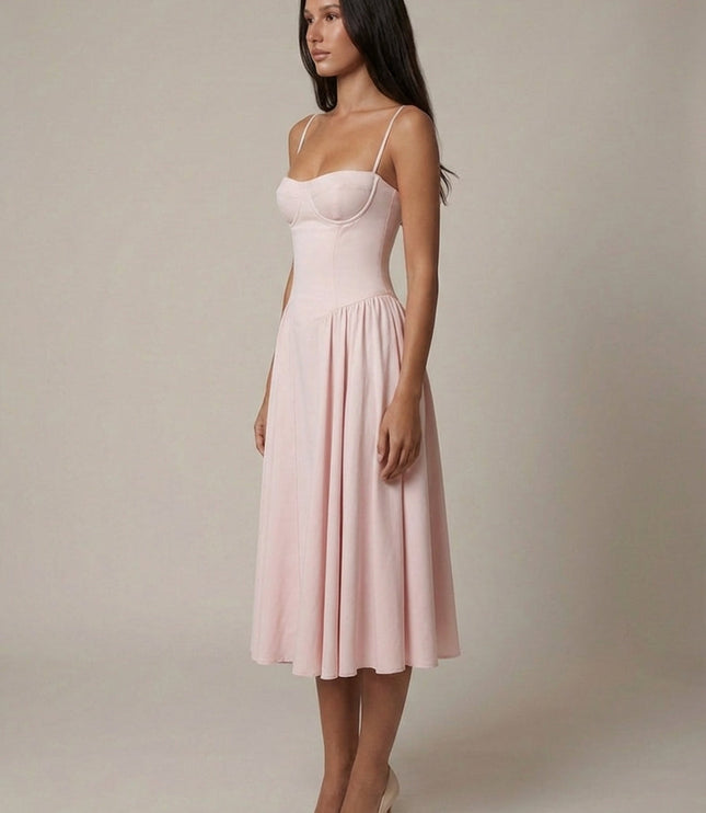 Three-quarter side view of blush midi dress with straps and softly pleated skirt