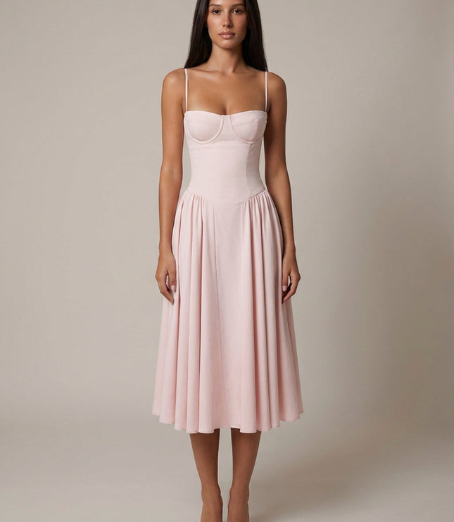Light pink midi dress with corset bodice, thin straps, and full wedding guest skirt