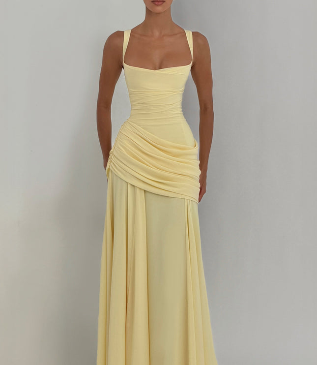 Front full-length pale yellow wedding guest maxi dress with cowl neckline and draped skirt