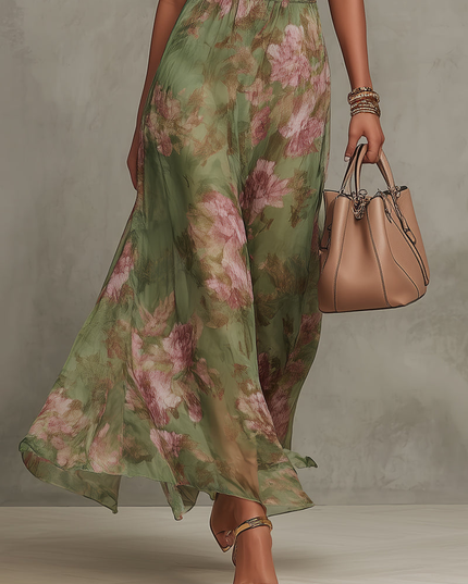 Flowing skirt detail of green floral halter maxi dress with pink roses