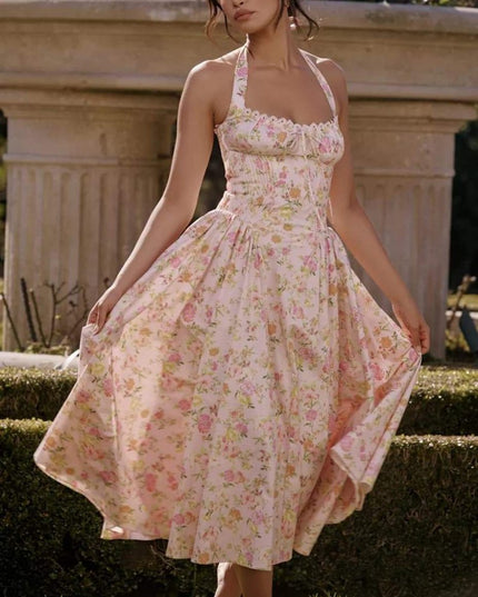 Front view of a pink floral halter midi dress with ruched bodice and flowy skirt