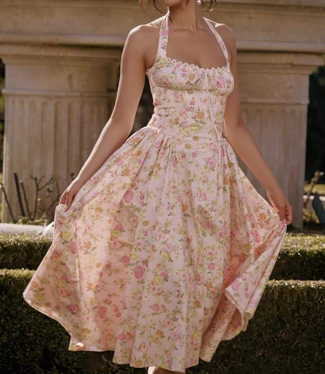 Front view of a pink floral halter midi dress with ruched bodice and flowy skirt