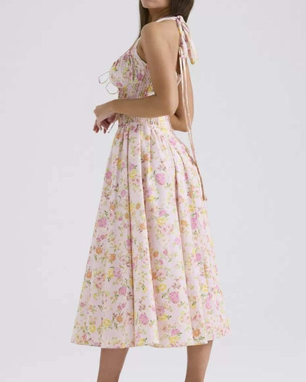 Side view of pink floral halter midi dress showing pleated skirt and fitted bodice