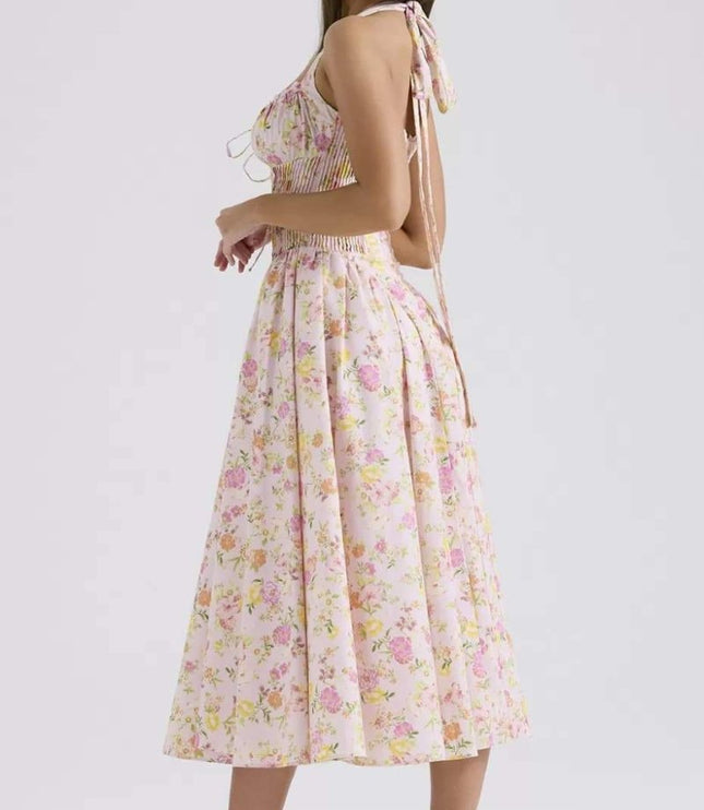 Side view of pink floral halter midi dress showing pleated skirt and fitted bodice