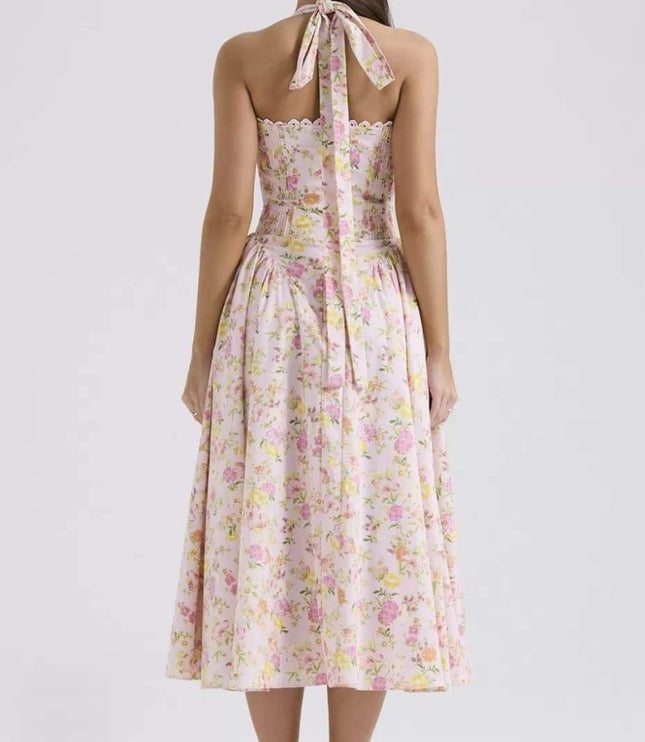 Back view of floral halter midi dress with tie neck, smocked back, and flowing skirt