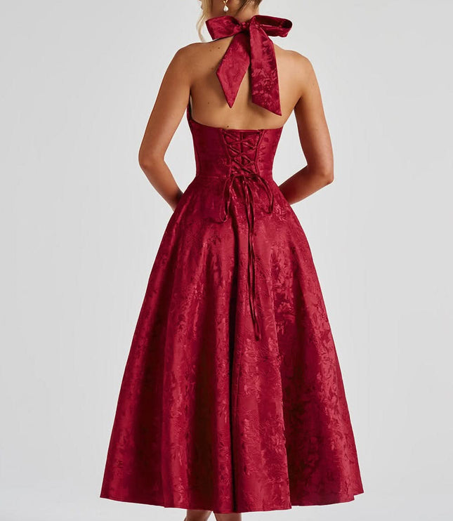 Back view of burgundy velvet halter dress with bow and lace-up