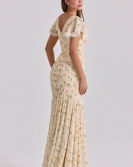 Side view of beige floral maxi dress showing flutter sleeves, deep V neck, and flowing skirt