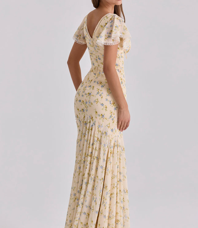 Side view of beige floral maxi dress showing flutter sleeves, deep V neck, and flowing skirt