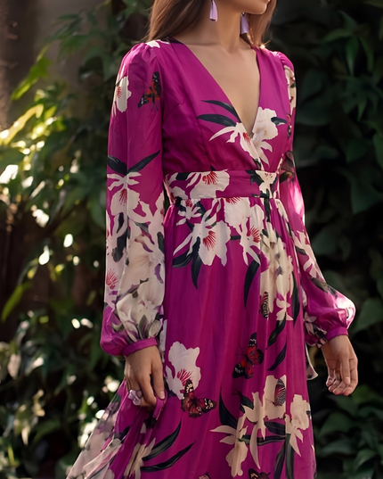 Close-up of floral V neck maxi dress showing long sleeves, fitted waist, and magenta print