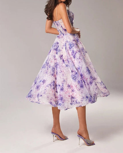 Side view of a purple floral midi dress with fitted bodice and flared wedding guest skirt