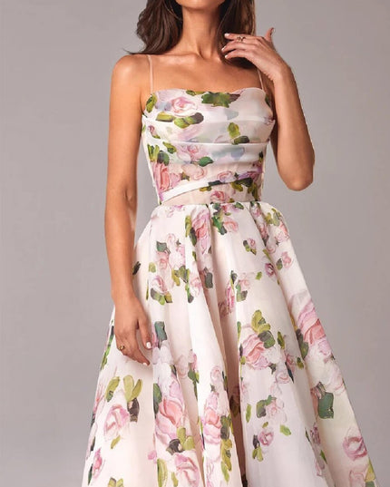 Close-up of floral midi dress with spaghetti straps, sheer midriff detail, and gathered skirt
