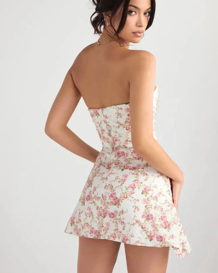 Back view of a floral strapless mini dress with smooth fitted silhouette and side drape detail