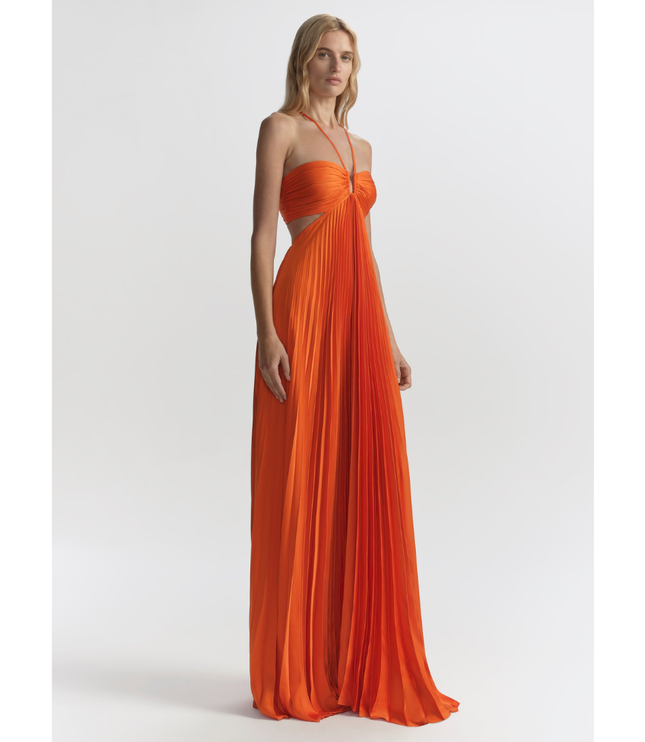 Orange wedding guest halter maxi pleated dress shown at 3/4 angle with flowy full-length skirt