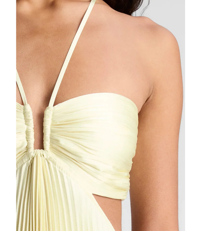 Detail close-up of pale yellow ruched bust, halter straps, and side cutout on pleated maxi dress