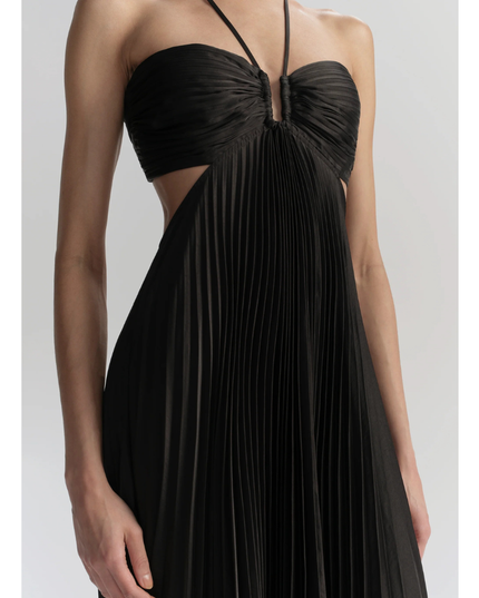Close-up of black halter maxi pleated dress showing ruched bodice, waist cutouts, and pleats