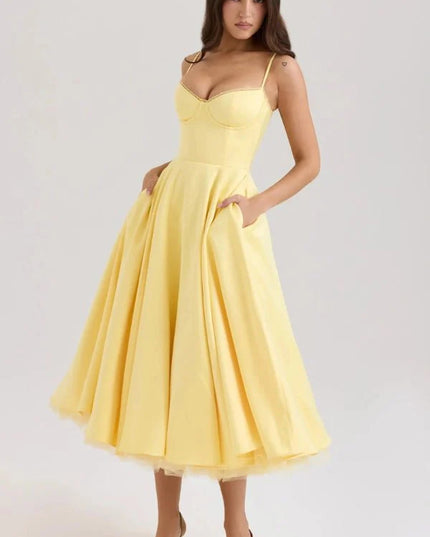 Yellow midi wedding guest dress with sweetheart neckline, straps, and full skirt