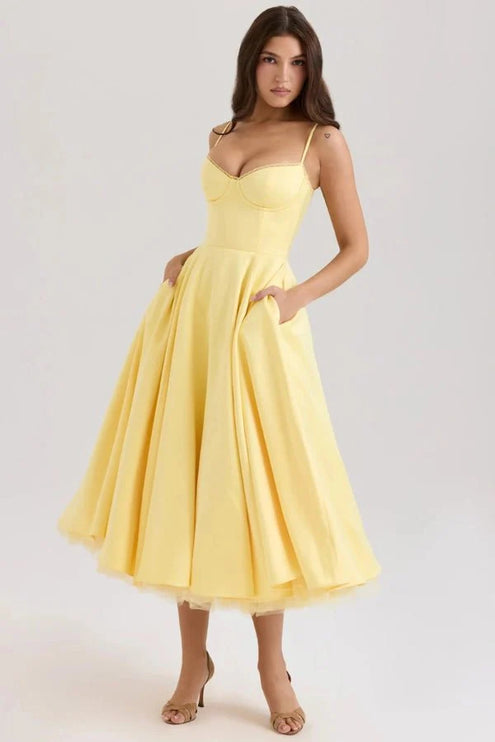 Yellow midi wedding guest dress with sweetheart neckline, straps, and full skirt
