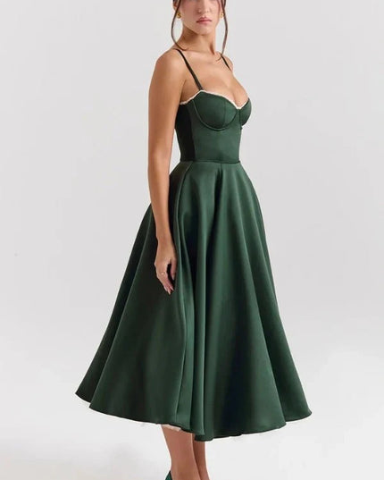 Side view of dark green midi dress showing open back, fitted waist, and flowing skirt