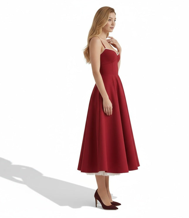 Side view of a burgundy wedding guest midi dress with flared skirt and shoulder straps