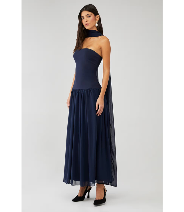 Front angled view of navy strapless maxi dress with flowing chiffon skirt