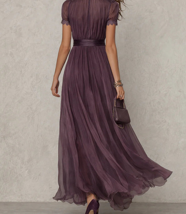 Back view of purple maxi dress with sheer short sleeves, fitted waist, and floor-length chiffon