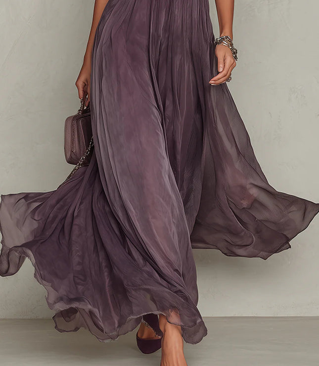 Close view of purple wedding guest dress showing keyhole front, puff sleeves, and airy maxi hem