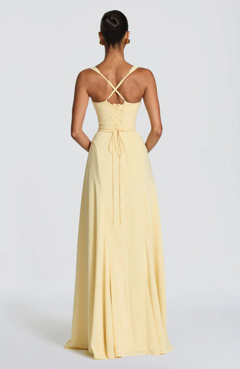 Back view of lemon yellow maxi dress with crisscross straps and lace-up bodice detail